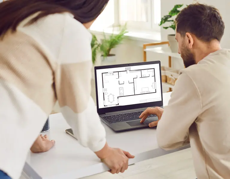 Paar nutzt Laptop mit Grundriss-Software zur digitalen Raumplanung und Einrichtungsgestaltung in heller Wohnumgebung, ideal für individuelle Wohnkonzepte und moderne Einrichtungsplanung.